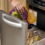 someone placing trash into a stainles steel trash compactor 
