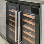 Black wine cooler with 5 wooden shelves and stainless steel handles and gray countertops